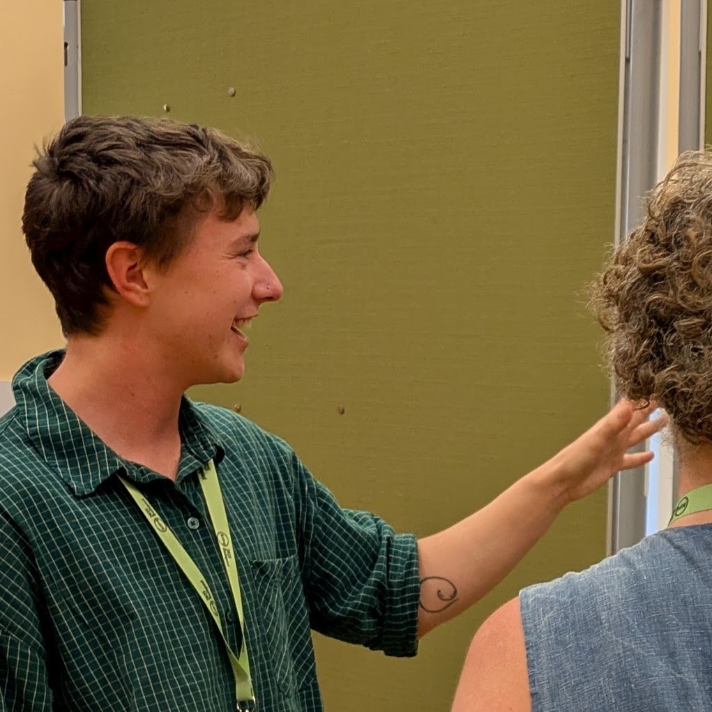 ze pointing at a poster with someone
